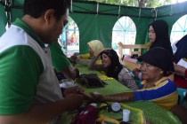 Seorang tenaga Medis PMI Jombang memeriksa pasien pengobatan gratis dalam Milad PT. BPRS Lantabur, Ahad (06/03/2016) di Alun-alun Jombang